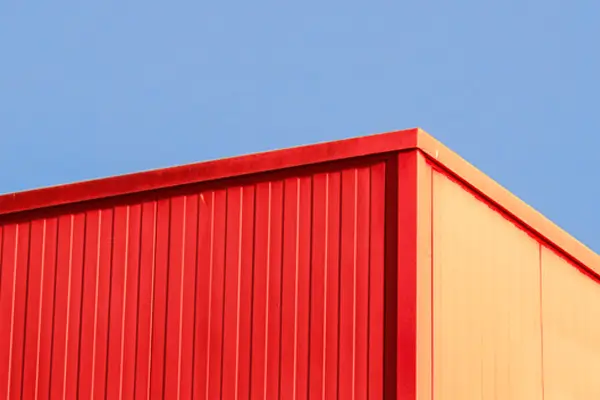 Esquina de container naranja con fondo de cielo azul